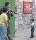 _imemc_org_attachments_dec2007_400_0___10000000_0_0_0_0_0_israeli_soldier_points_his_gun_at_a_palestinian_child_in_hebron_city_2007.jpg